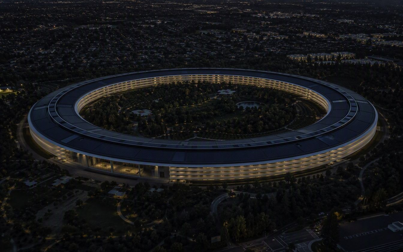 Aerial view of Apple Park in Cupertino: the vast circular glass ring designed by Foster + Partners set in landscaped parkland of drought-resistant trees.